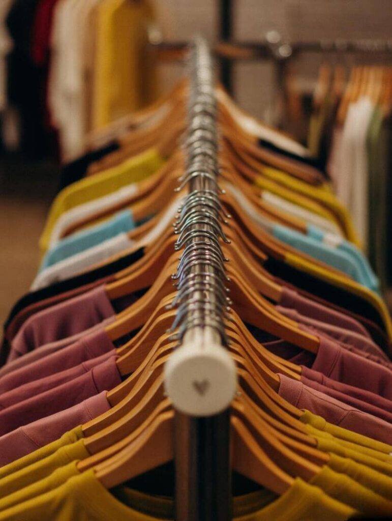 Thrift store rack, sneakers peeking, heart-hanger.